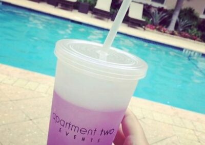 Cup with straw showing logo by pool